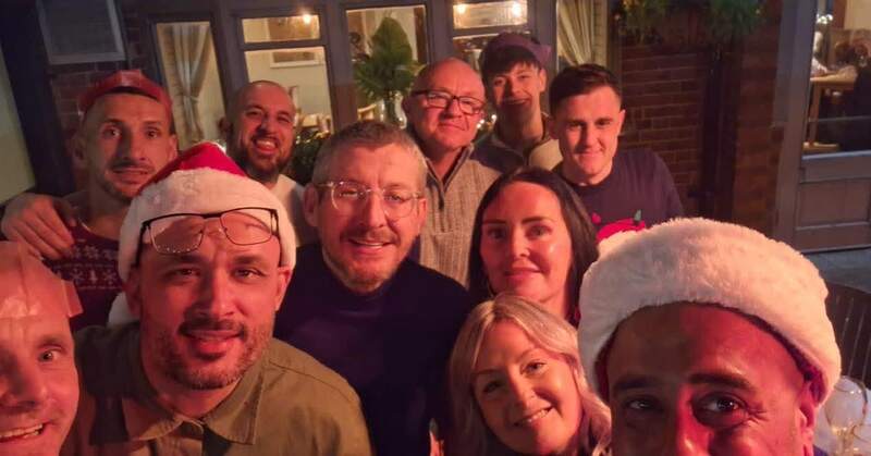A group selfie of the Seasons team in Christmas hats