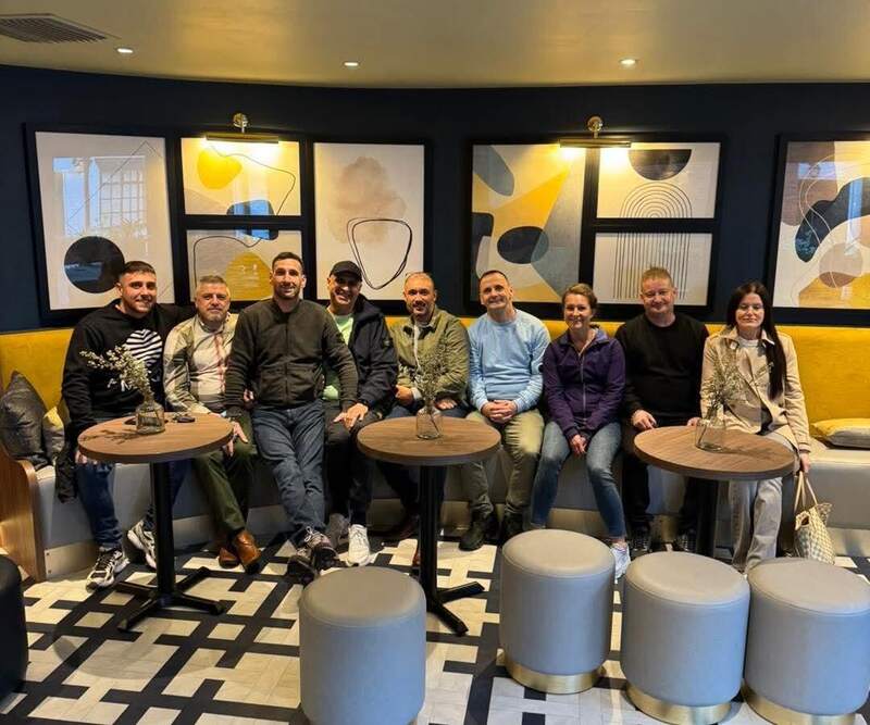 Members of the Seasons team sitting together on a yellow sofa