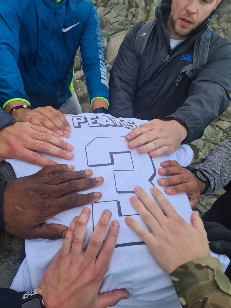 Hands placed together on a white 3 Peaks shirt