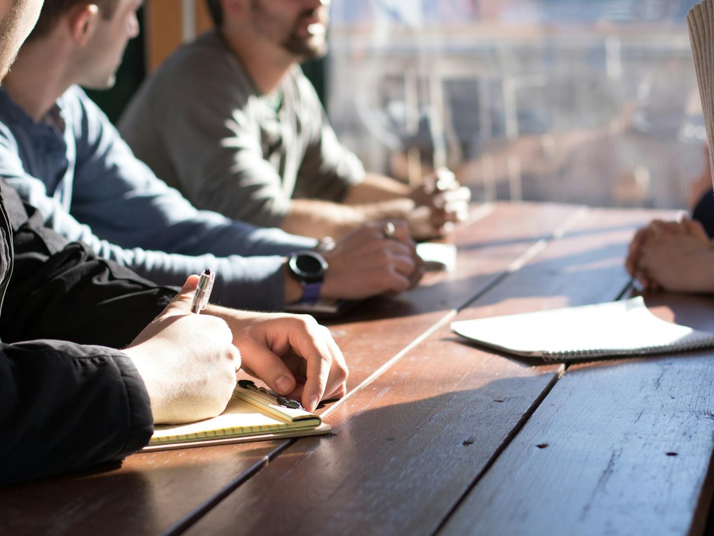 People sitting around a table taking notes during a group session